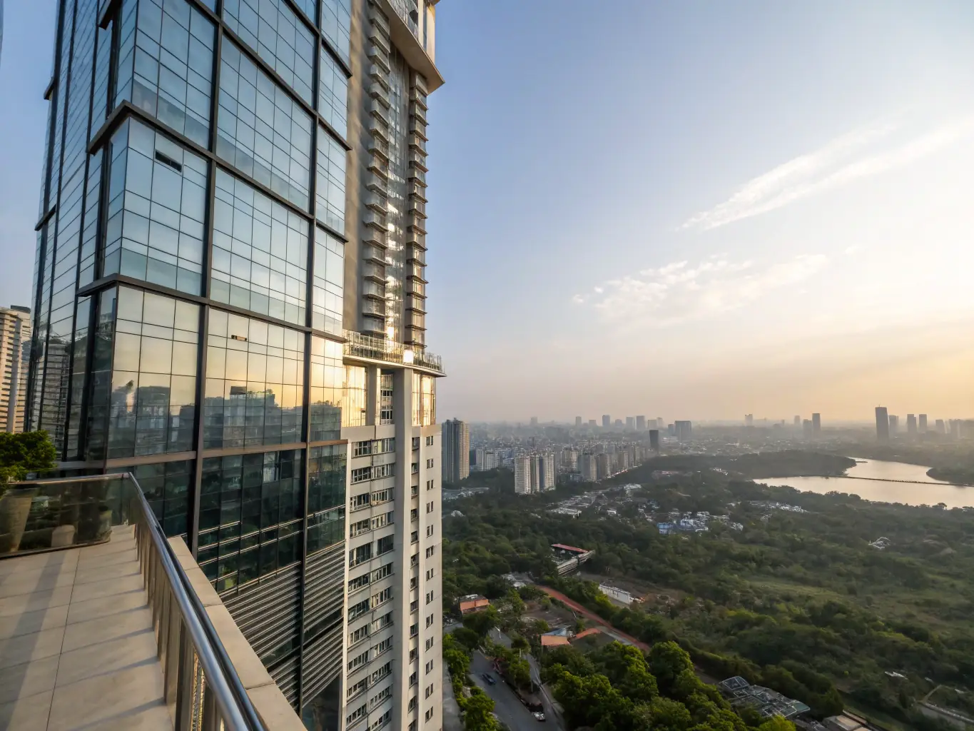 A high-angle, daytime shot of Skyline Residency, a modern residential tower with glass facade, showcasing its panoramic city views and luxurious design.